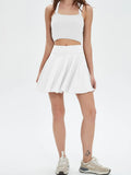 Woman in white high waisted tennis mini skirt with crop top