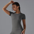 Woman in light beige crew neck yoga vest training top with leggings