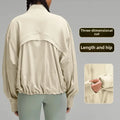 Light beige relaxed fit athletic jacket with stand collar over green leggings
