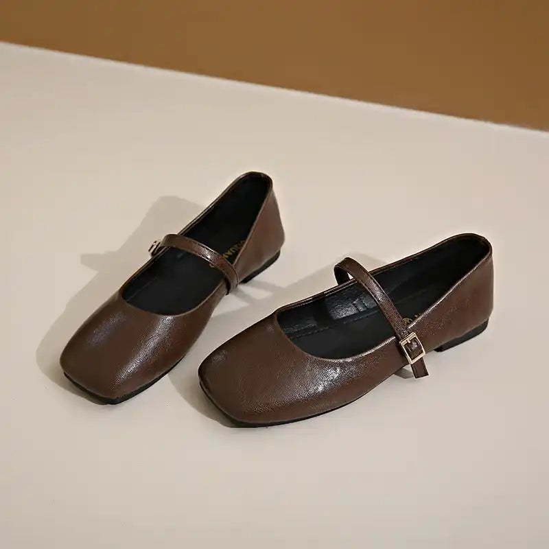 Two square-toe brown Mary Jane flats with buckled straps.