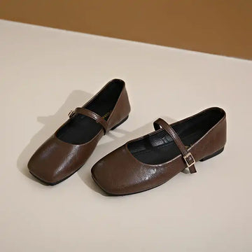 Two square-toe brown Mary Jane flats with buckled straps.