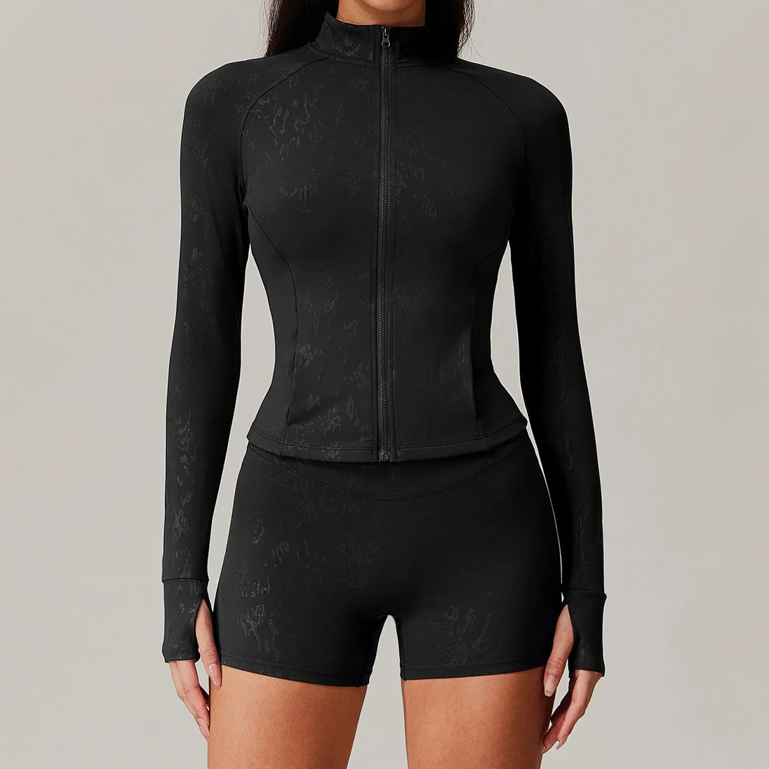 Woman in beige women yoga zipper jacket with thumbholes and biker shorts