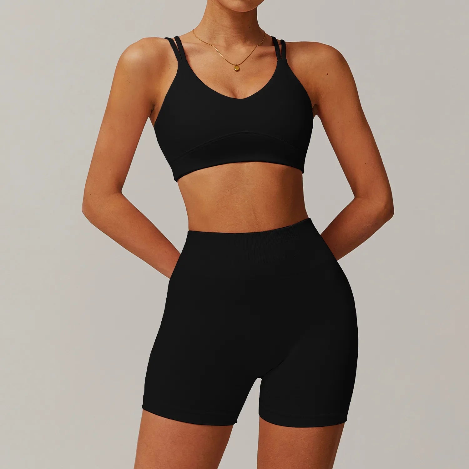 Black two-piece athletic set with v-neck sports bra and high-waisted biker shorts, perfect as a yoga suit 2pcs or 2pcs sports set
