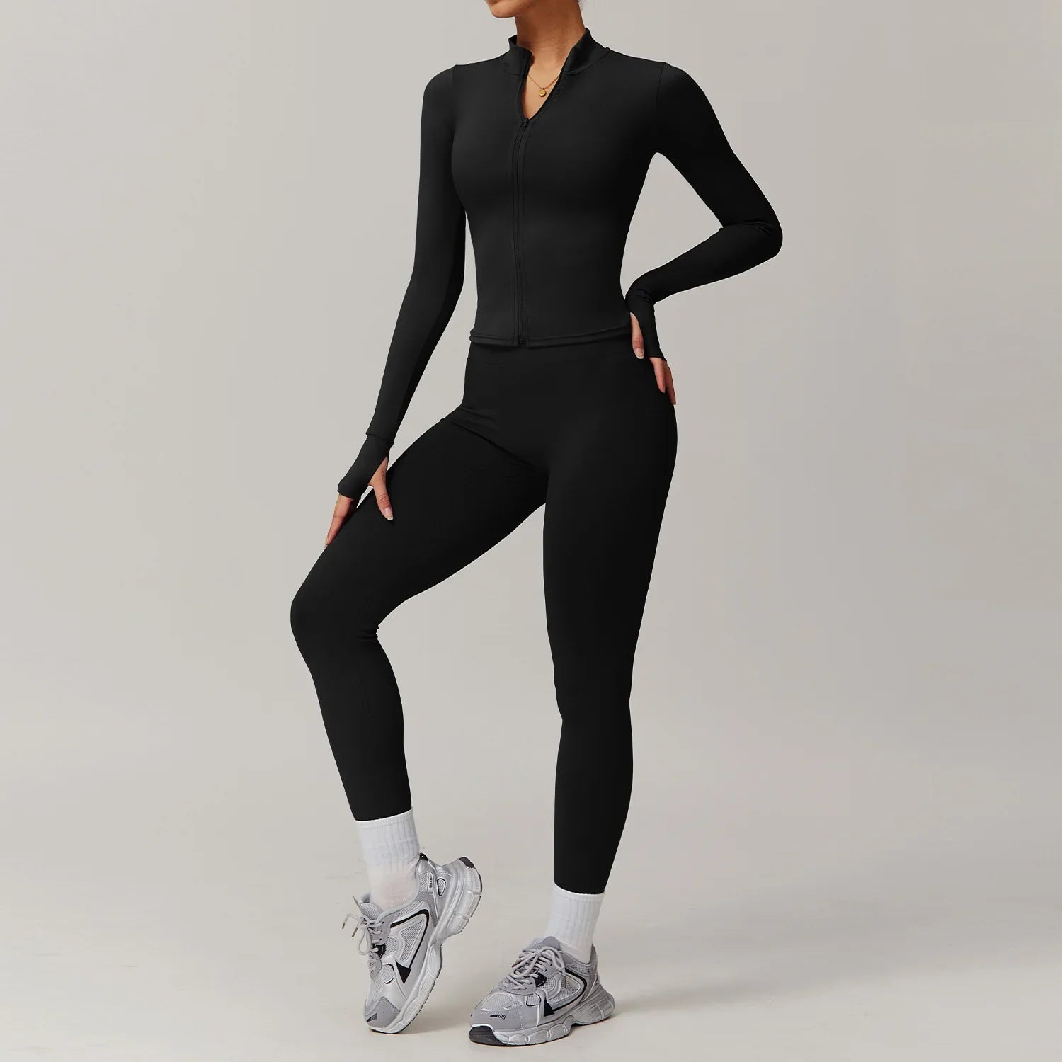 Woman modeling black long-sleeved yoga suit 2pcs sports set with matching leggings and sneakers