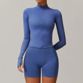 Woman wearing blue athletic 2pcs sports set with fitted long-sleeve top and biker shorts